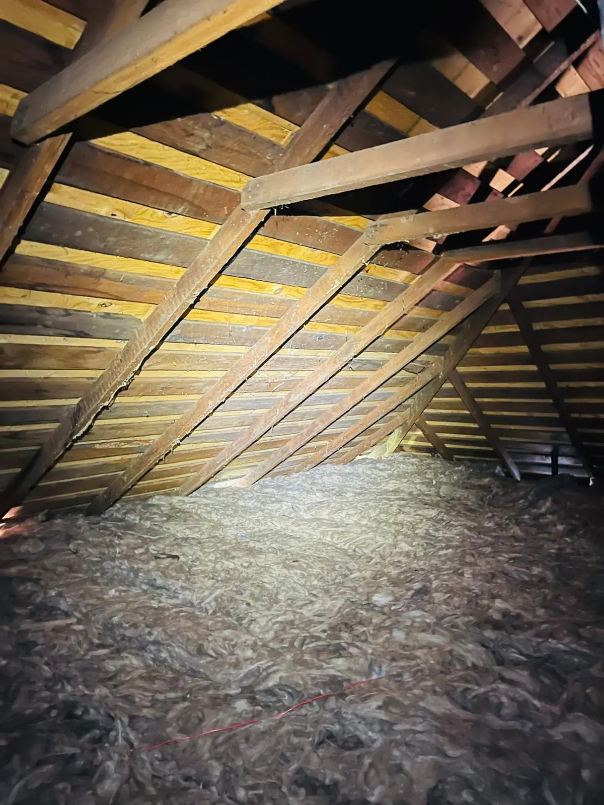 An even layer of new insulation across the attic floor.