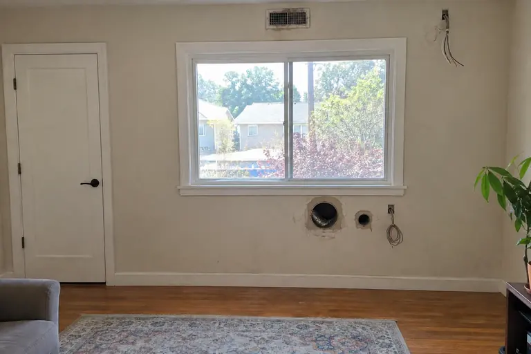 Ductless mini-split installation, before: Living room wall with old line-set holes and no cooling.
