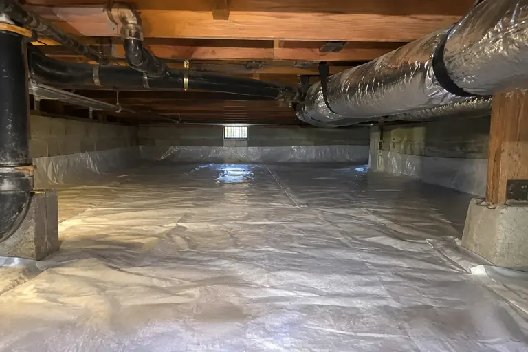 Crawl space cleaned and sealed with a vapor barrier, after: Crawl space cleaned and covered with a new vapor barrier.