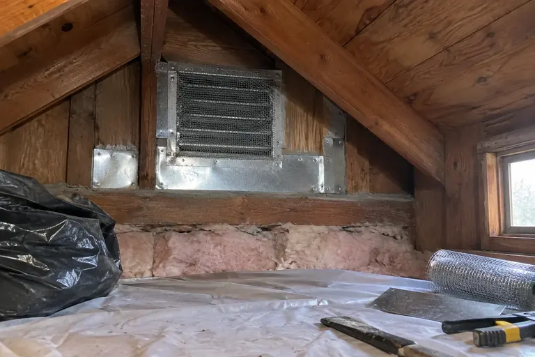 Attic vent sealed with steel mesh, after: Vent re-screened and the gaps closed with galvanized sheet metal.