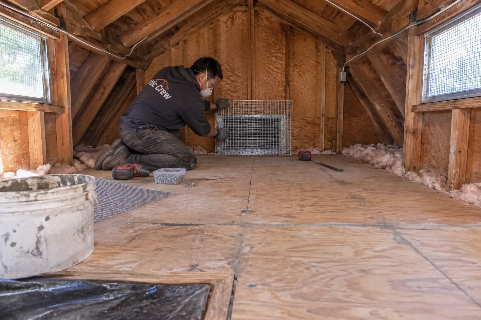 Fitting steel mesh over an attic gable vent.