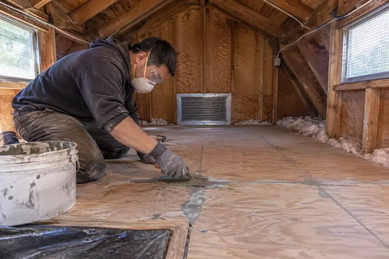 Sealing gaps along the attic floor to close rodent entry points.